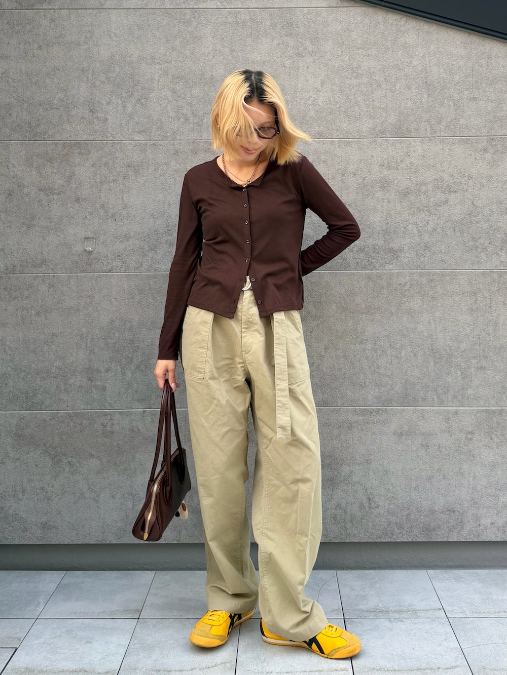 ベージュ系のその他パンツ、イエロー系のスニーカー、ブラウン系のカーディガン/ボレロを着用したレディースの春コーディネートの2枚目の写真