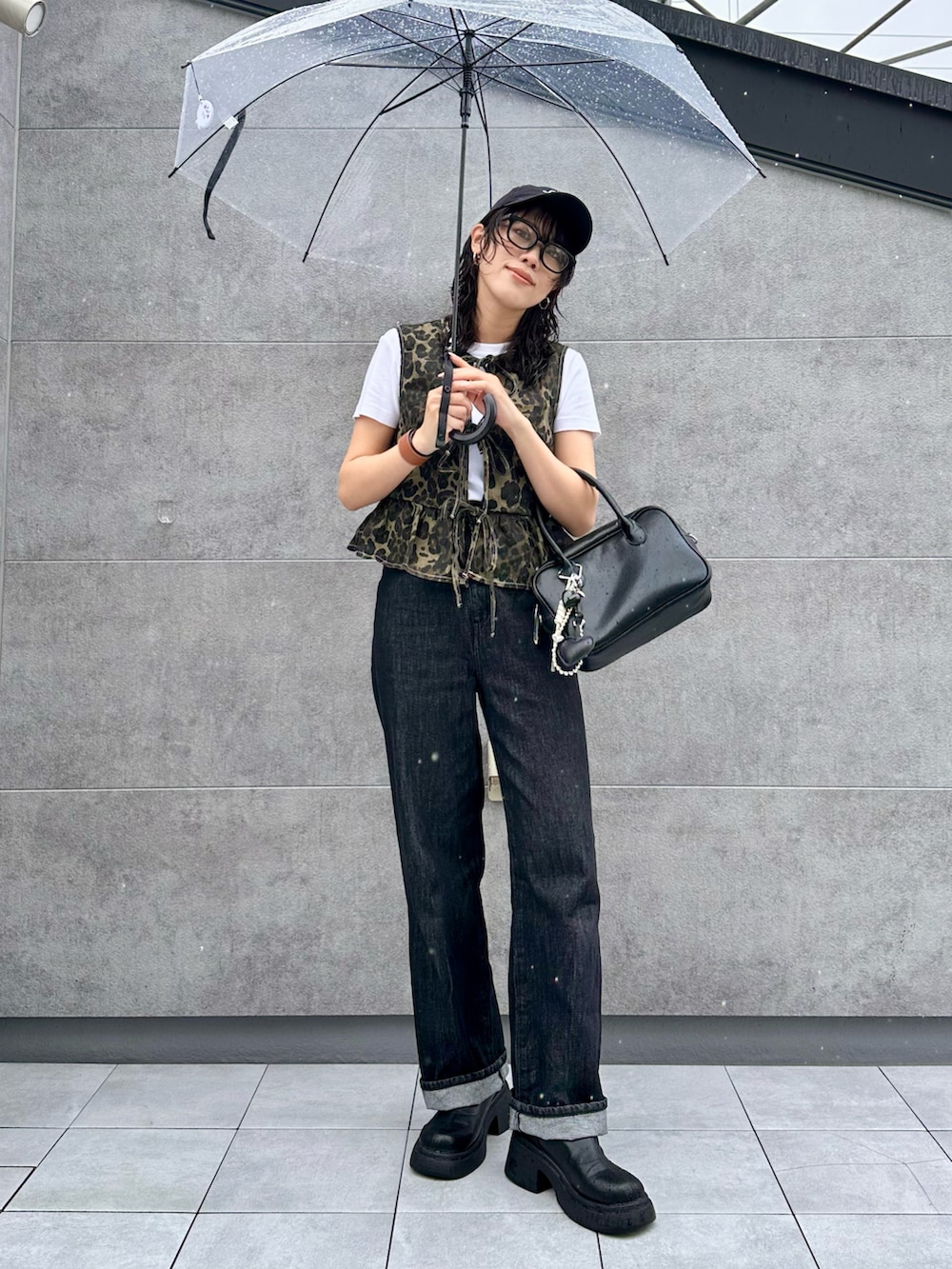 ブラック系のボストンバッグ、ブラック系のデニムパンツ、ブラック系のキャップを着用したレディースの夏コーディネートの3枚目の写真