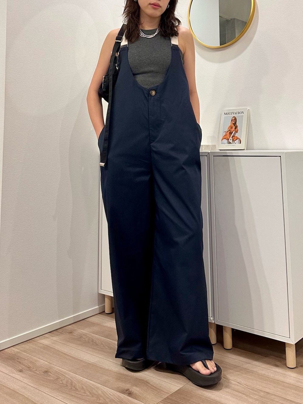 グレー系のタンクトップ、ブルー系のサロペット/オーバーオール、ブラック系のサンダルを着用したレディースの夏コーディネートの3枚目の写真