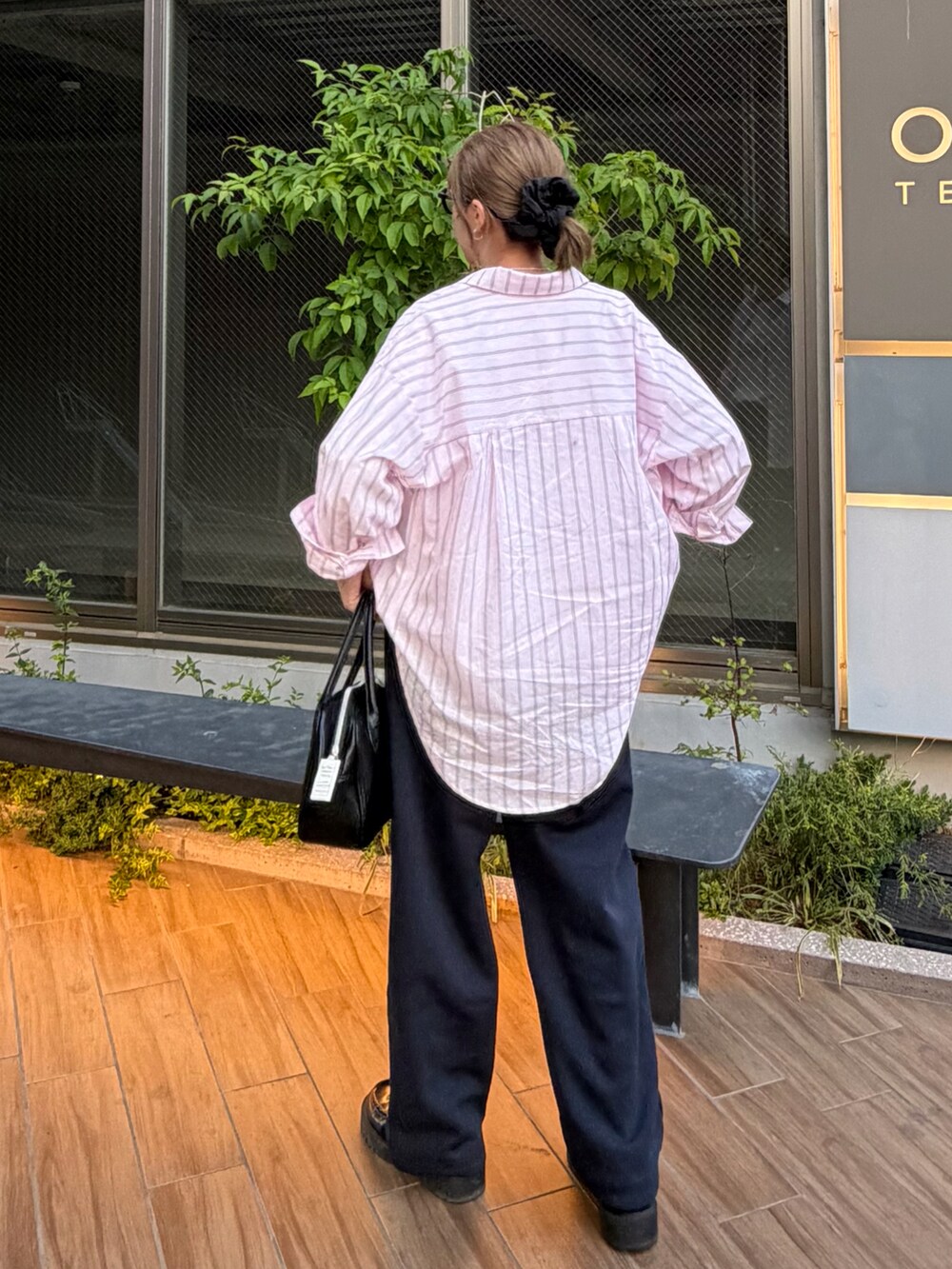 ブラック系のボストンバッグ、ホワイト系のTシャツ/カットソー、ピンク系のシャツ/ブラウスを着用したレディースの春コーディネートの2枚目の写真