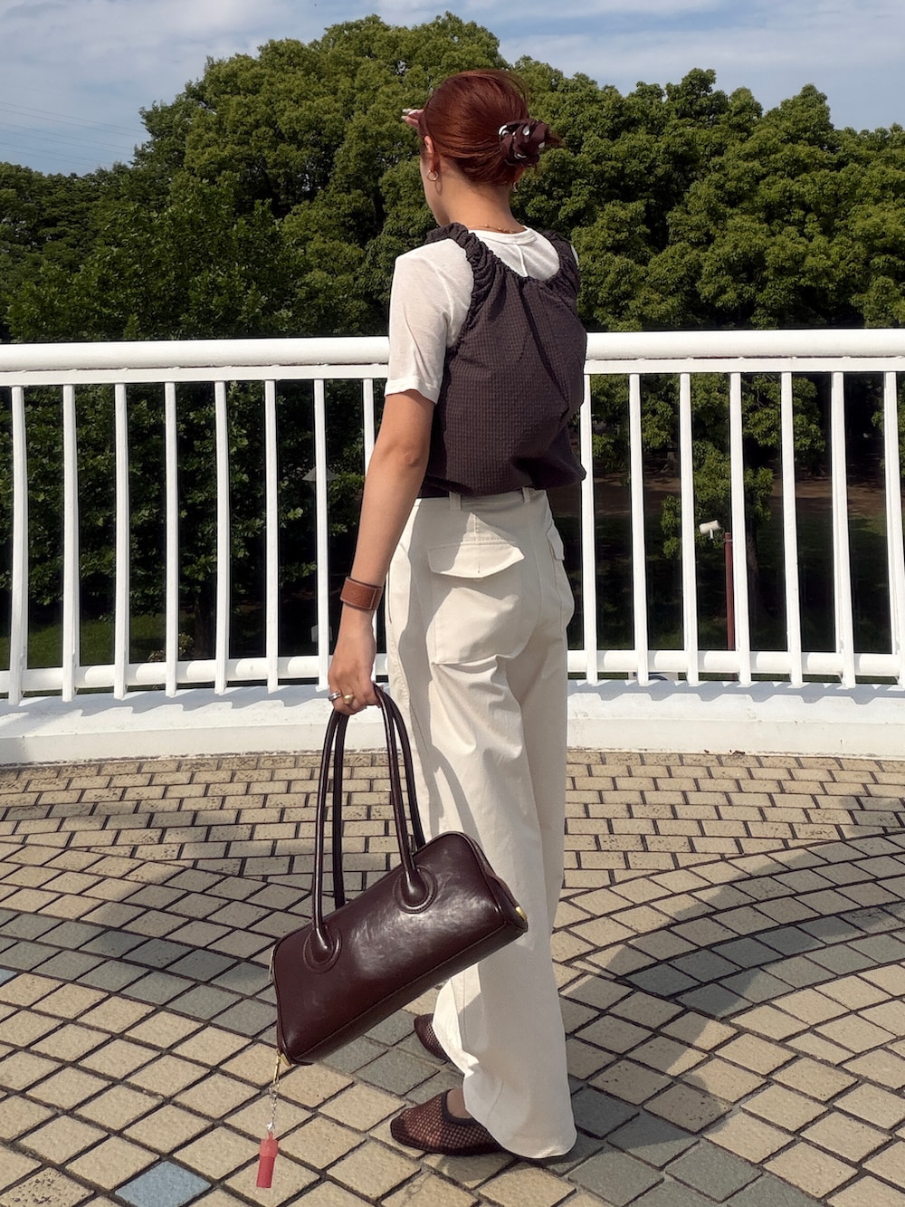 ブラウン系のタンクトップ、ブラウン系のサンダル、ブラウン系のボストンバッグを着用したレディースの夏コーディネートの3枚目の写真