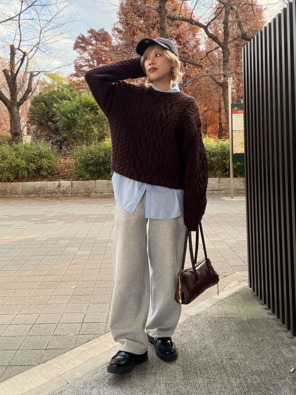 ブルー系のシャツ/ブラウス、ブラウン系のニット/セーター、グレー系のスウェットパンツを着用したレディースの冬コーディネートの2枚目の写真