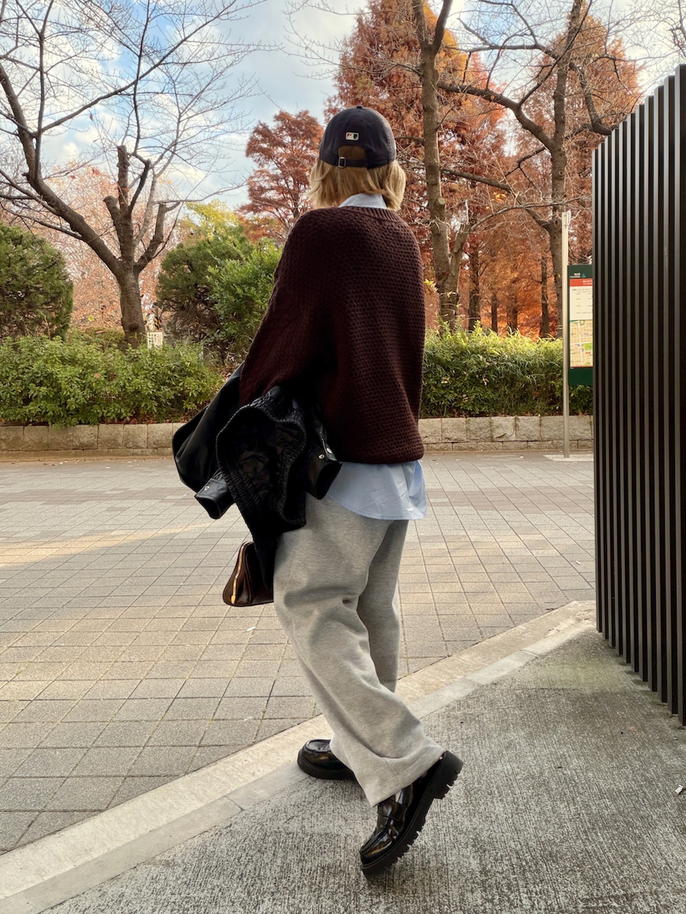 ブルー系のシャツ/ブラウス、ブラウン系のニット/セーター、グレー系のスウェットパンツを着用したレディースの冬コーディネートの3枚目の写真