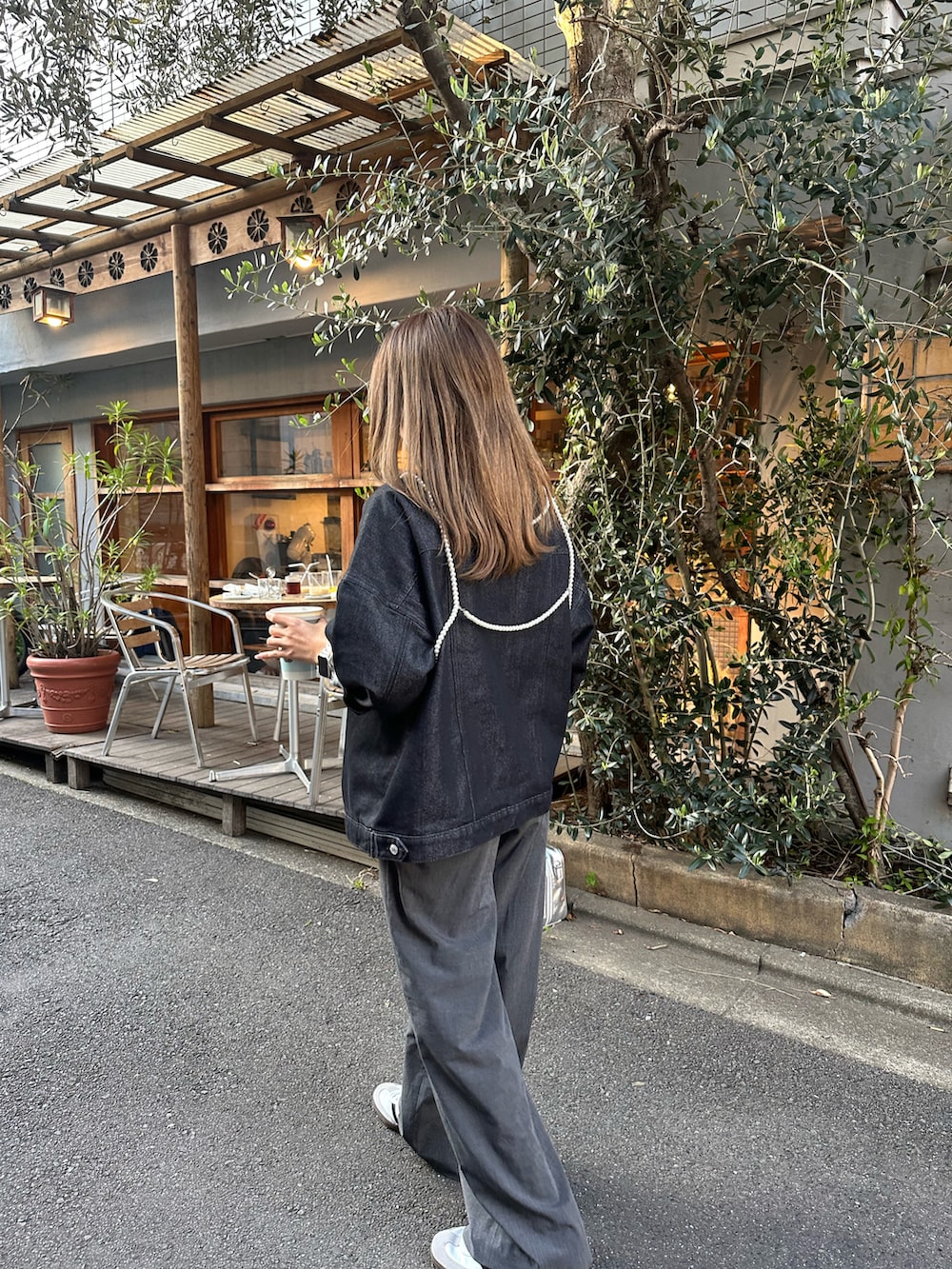 ホワイト系のスニーカー、グレー系のスラックス、シルバー系のボストンバッグを着用したレディースの春コーディネートの2枚目の写真