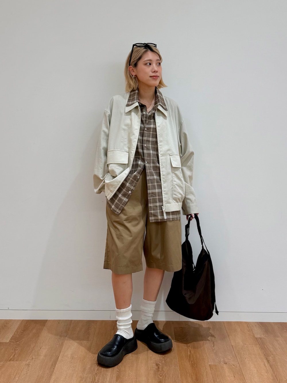 ブラック系のサンダル、ホワイト系のブルゾン、ブラウン系のシャツ/ブラウスを着用したレディースの春コーディネートの2枚目の写真