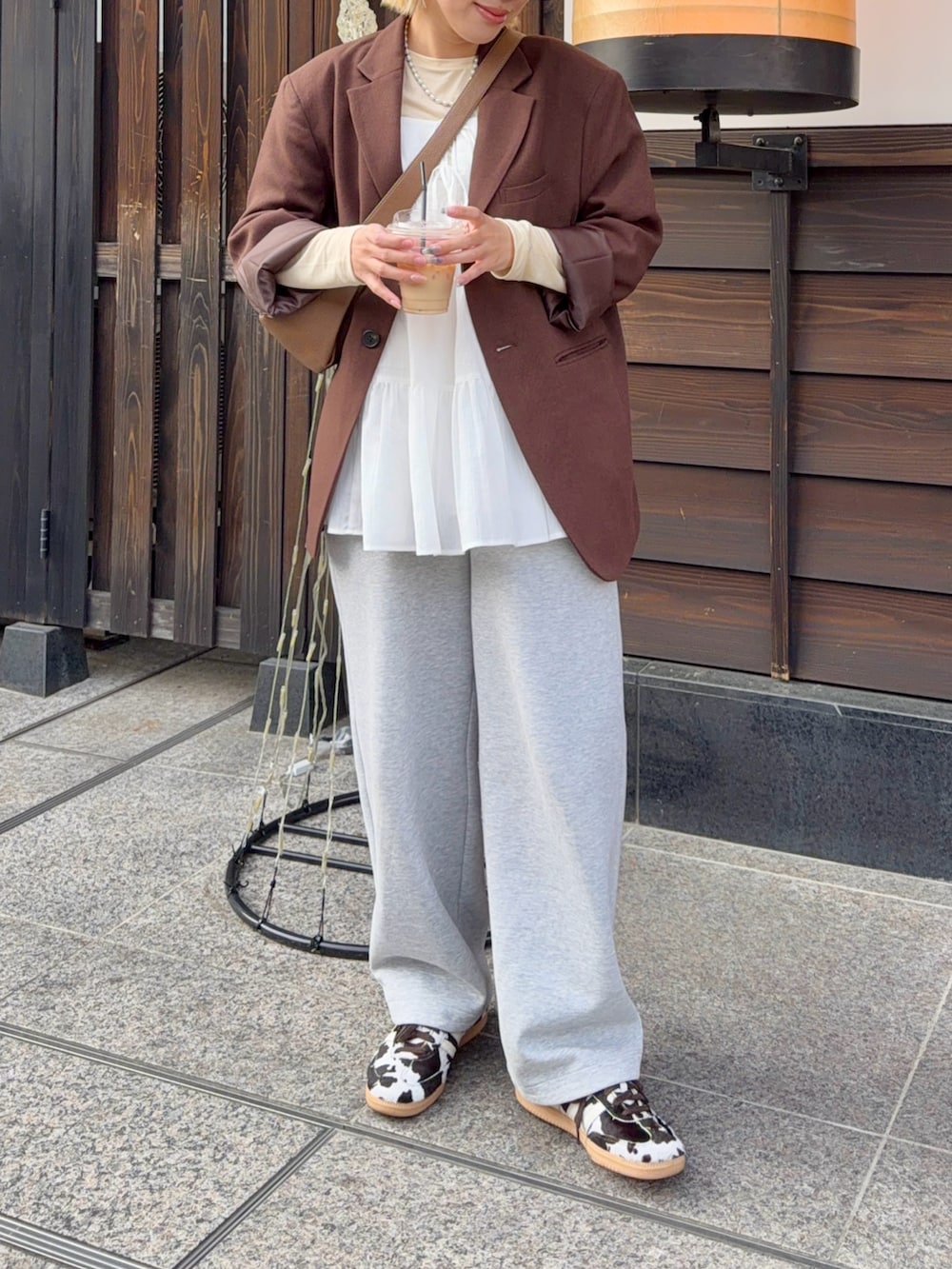 グレー系のスウェットパンツ、ブラウン系のスニーカー、ブラウン系のテーラードジャケットを着用したレディースの春コーディネートの3枚目の写真