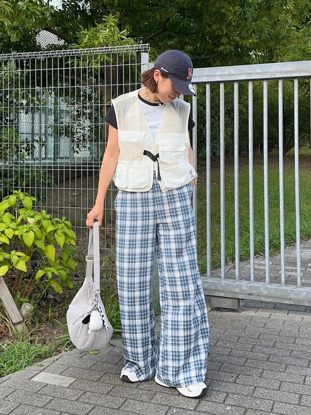グレー系のショルダーバッグ、ブルー系のその他パンツ、ホワイト系のベストを着用したレディースの夏コーディネートの3枚目の写真