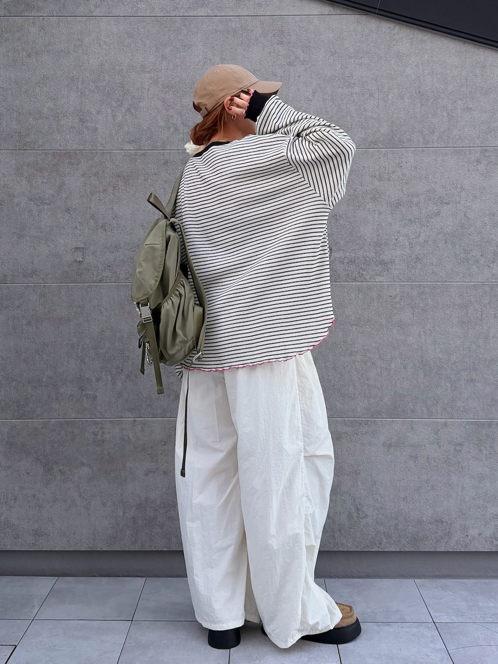 ホワイト系のTシャツ/カットソー、グリーン系のバックパック/リュック、ベージュ系のサンダルを着用したレディースの秋コーディネートの3枚目の写真