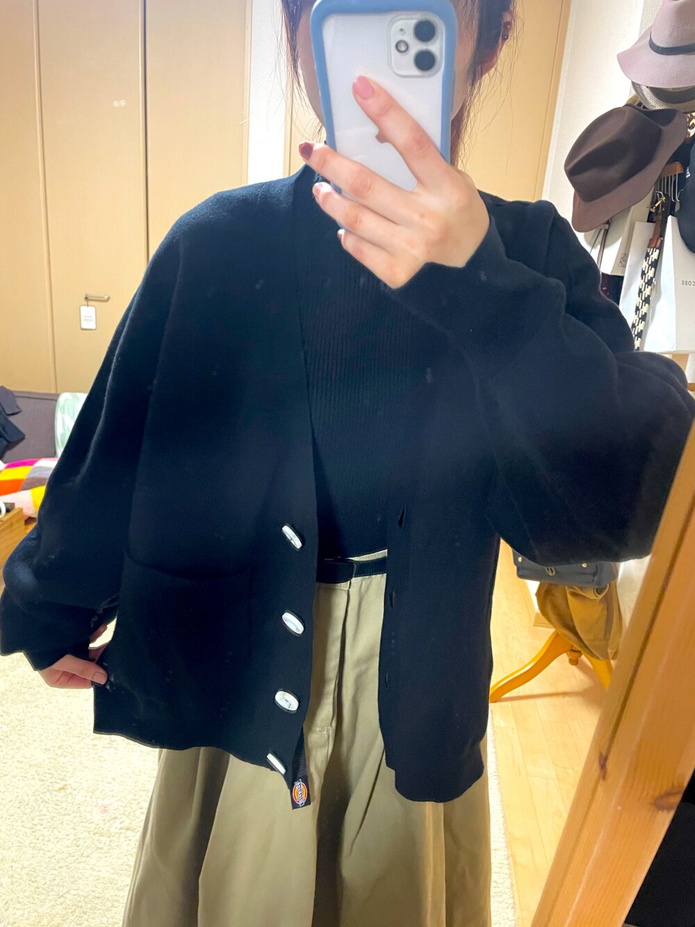 ブラック系のカーディガン/ボレロ、ベージュ系のスカート、ブラック系のトップスを着用したレディースの秋コーディネートの2枚目の写真