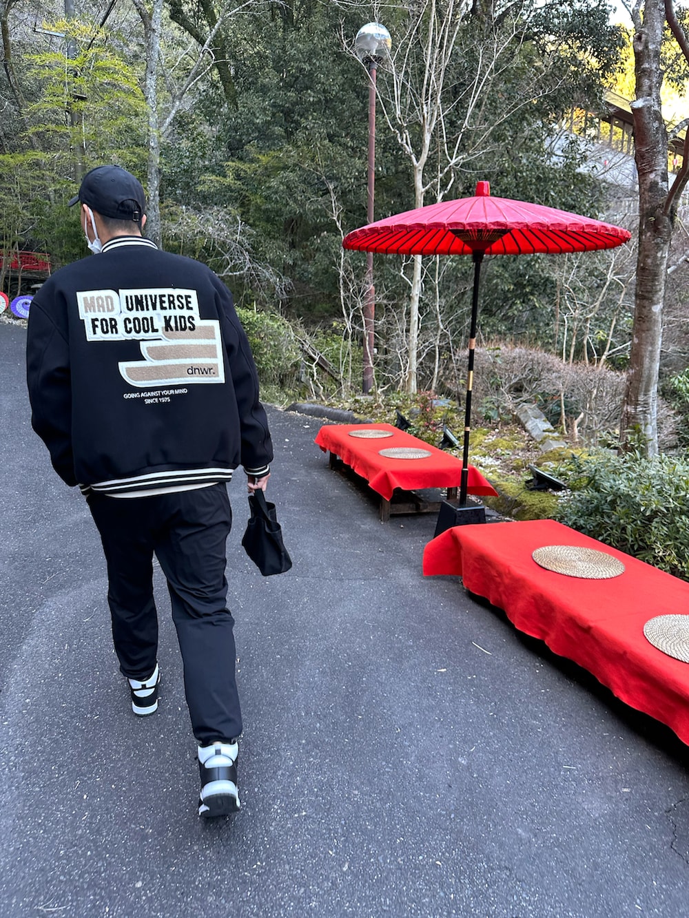 ブラック系のスウェットパンツ、ブラック系のスニーカー、ブラック系のスタジャンを着用したメンズの春コーディネートの2枚目の写真