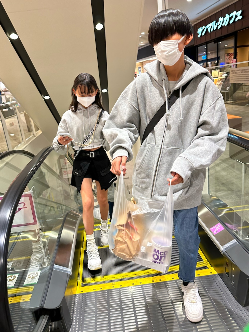 グレー系のパーカー、ブルー系のデニムパンツ、ホワイト系のスニーカーを着用したキッズの春コーディネートの2枚目の写真