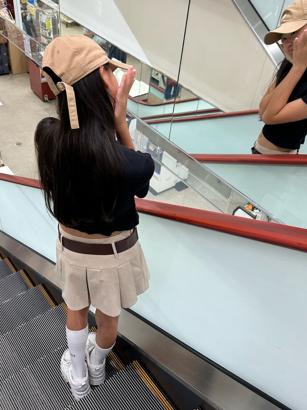 ブラック系のTシャツ/カットソー、ベージュ系のスカート、ホワイト系のスニーカーを着用したキッズの秋コーディネートの2枚目の写真