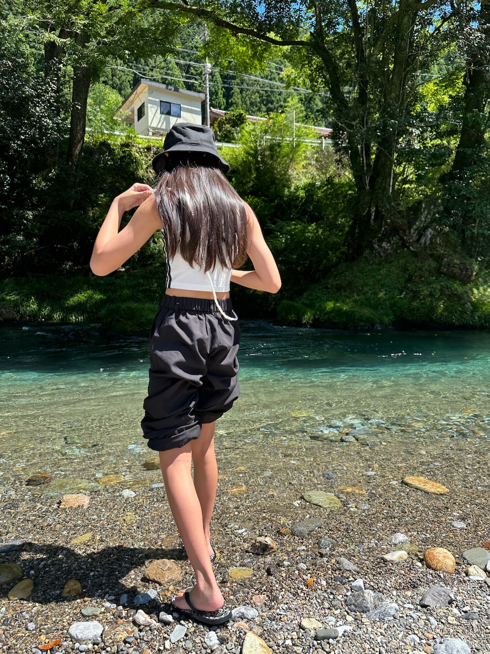 ホワイト系のタンクトップ、ブラック系のカーゴパンツ、ブラック系のハットを着用したキッズの秋コーディネートの2枚目の写真