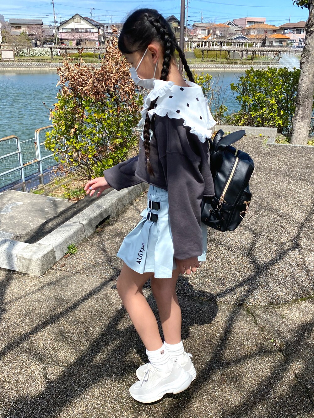 ホワイト系のスニーカー、ブルー系のスカート、グレー系のスウェットを着用したキッズの春コーディネートの2枚目の写真