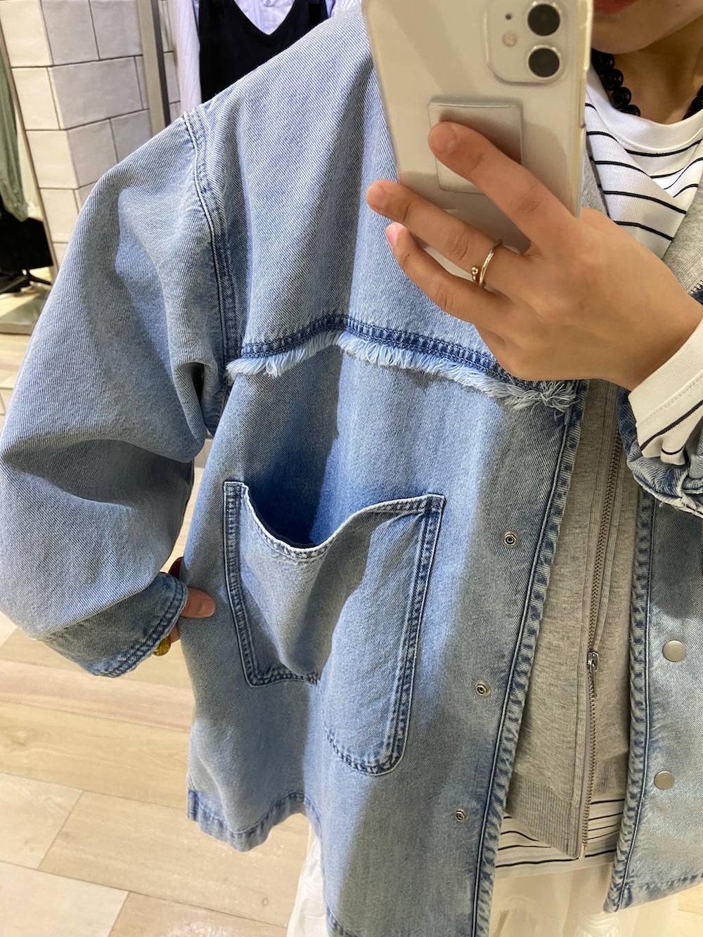 グレー系のベスト、ホワイト系のTシャツ/カットソー、ホワイト系のスカートを着用したレディースの冬コーディネートの3枚目の写真