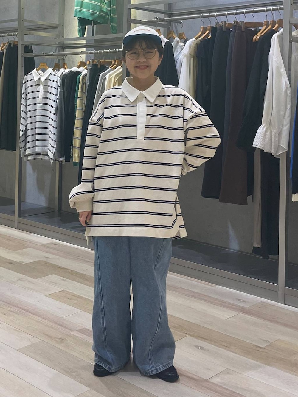 ブルー系のデニムパンツ、ブラック系のローファー、ホワイト系のキャップを着用したレディースの冬コーディネートの4枚目の写真