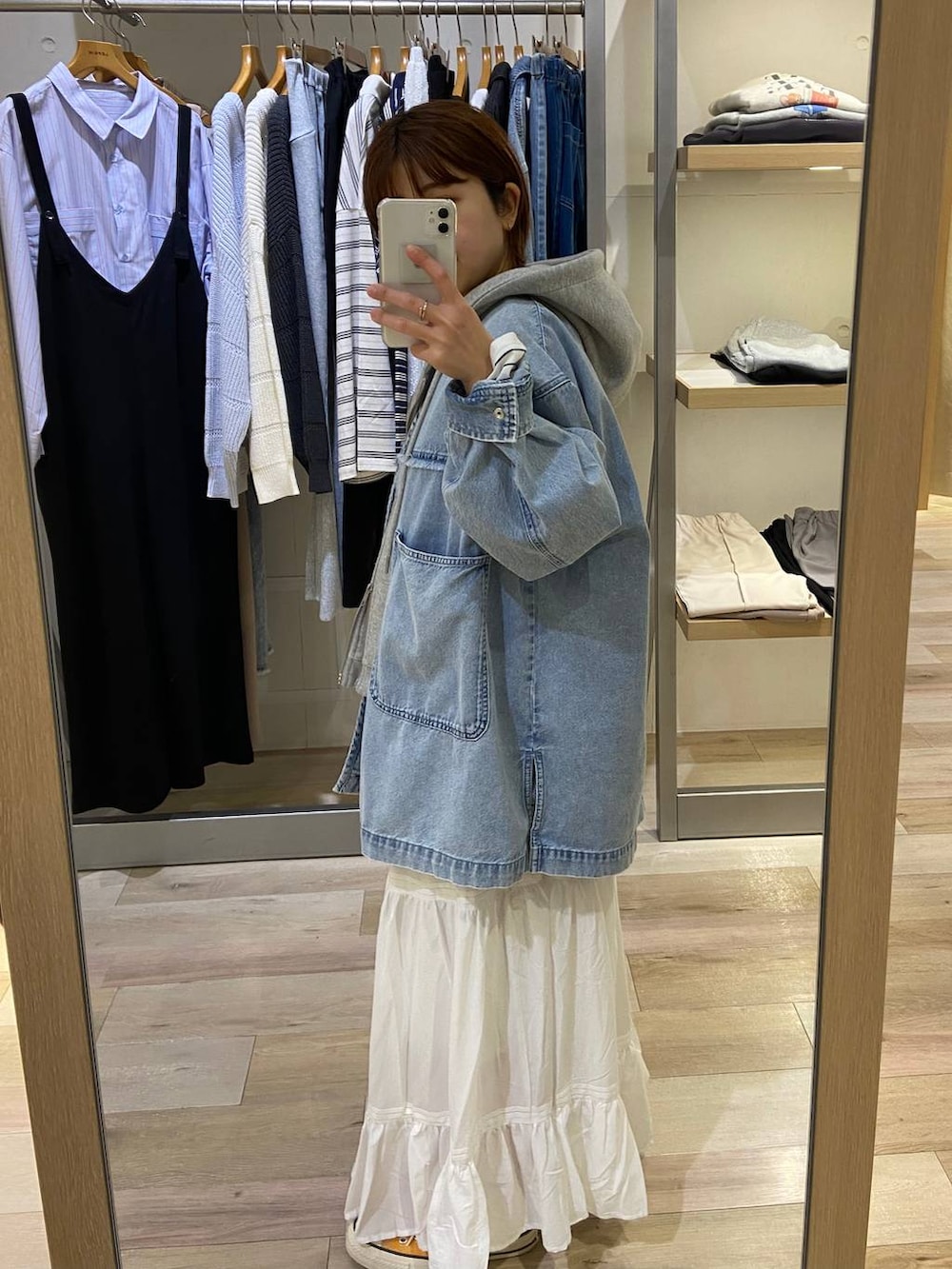 グレー系のベスト、ホワイト系のTシャツ/カットソー、ホワイト系のスカートを着用したレディースの冬コーディネートの2枚目の写真