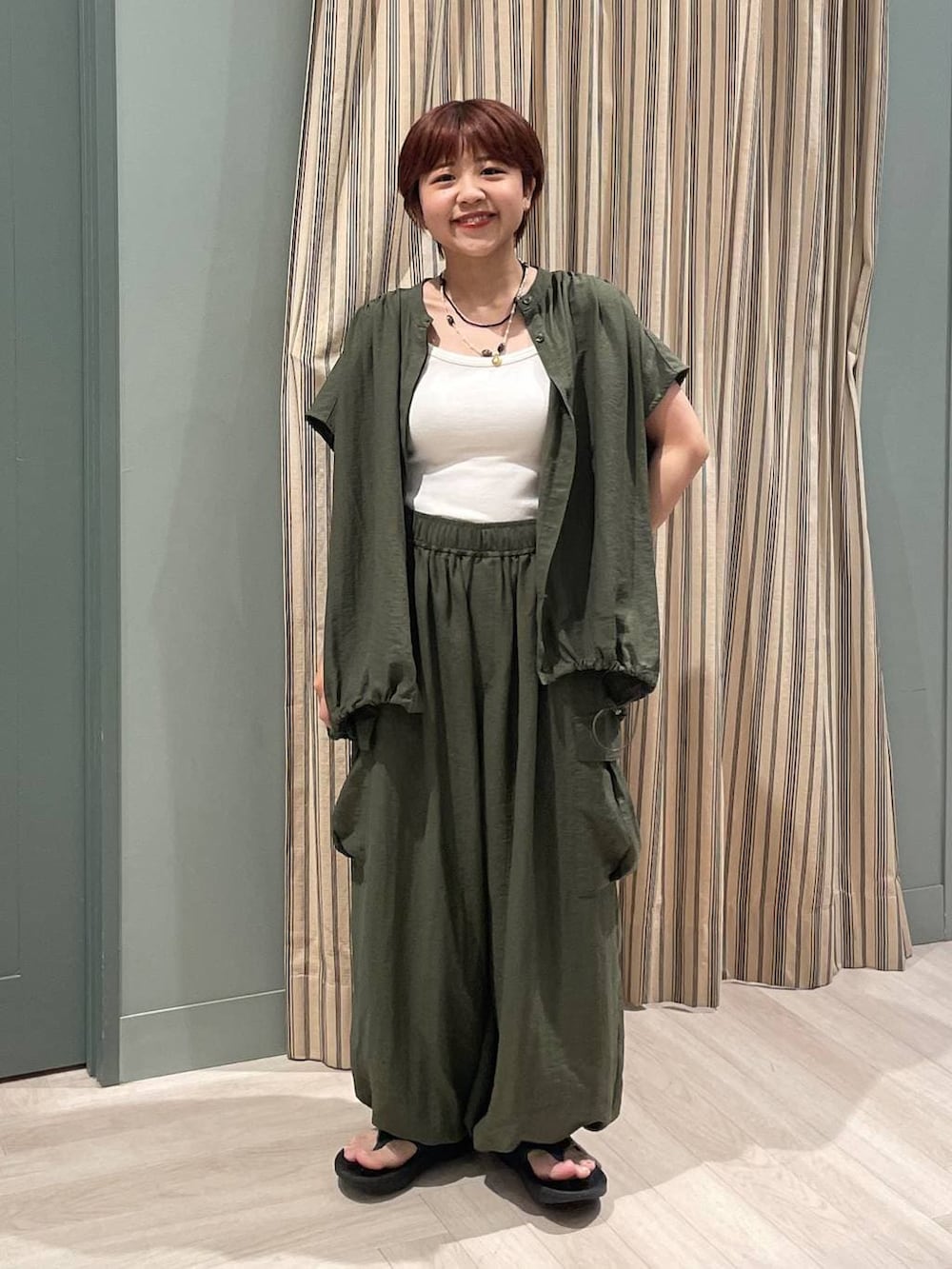 グリーン系のカーゴパンツ、グリーン系のシャツ/ブラウス、ベージュ系のキャミソールを着用したレディースの夏コーディネートの4枚目の写真