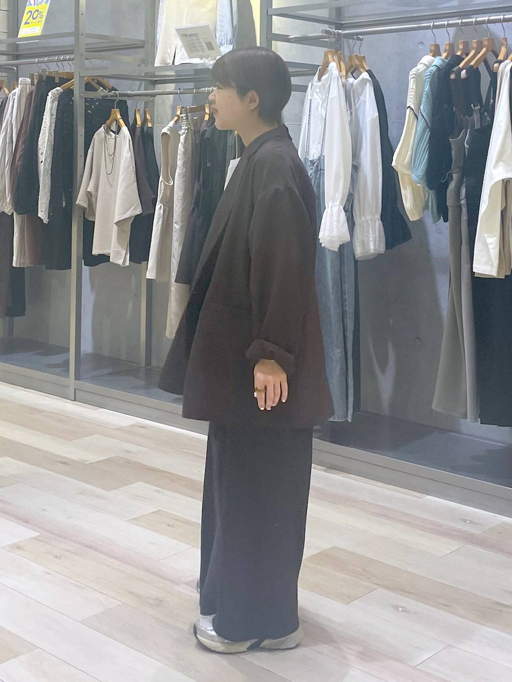 ブラウン系のテーラードジャケット、ブラック系のスカート、グレー系のTシャツ/カットソーを着用したレディースの春コーディネートの2枚目の写真