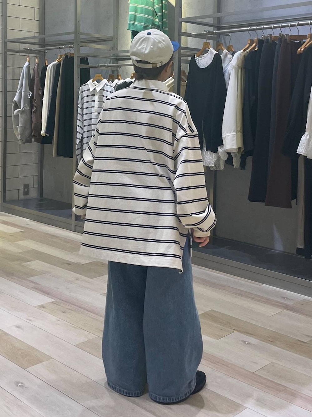 ブルー系のデニムパンツ、ブラック系のローファー、ホワイト系のキャップを着用したレディースの冬コーディネートの3枚目の写真