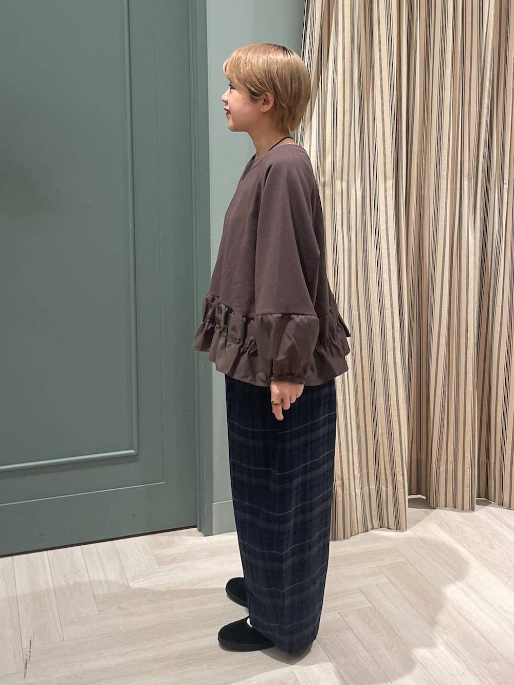 グレー系のその他パンツ、ブラック系のスニーカーを着用したレディースの秋コーディネートの2枚目の写真
