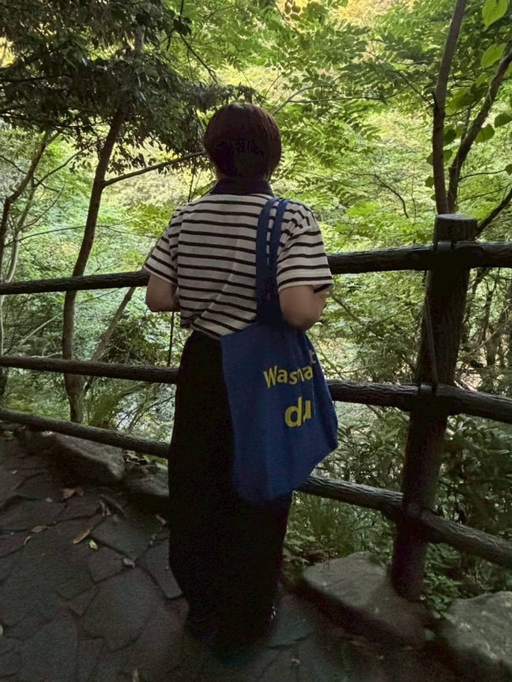ホワイト系のポロシャツを着用したレディースの夏コーディネートの2枚目の写真