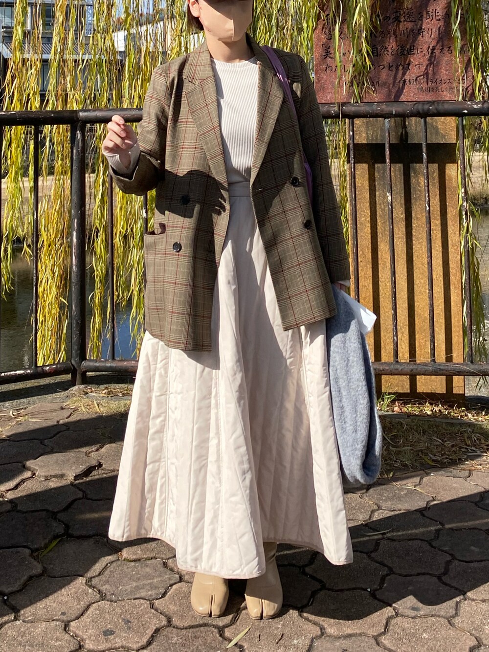 ホワイト系のスカート、ブラウン系のテーラードジャケット、ベージュ系のブーツを着用したレディースの冬コーディネートの2枚目の写真