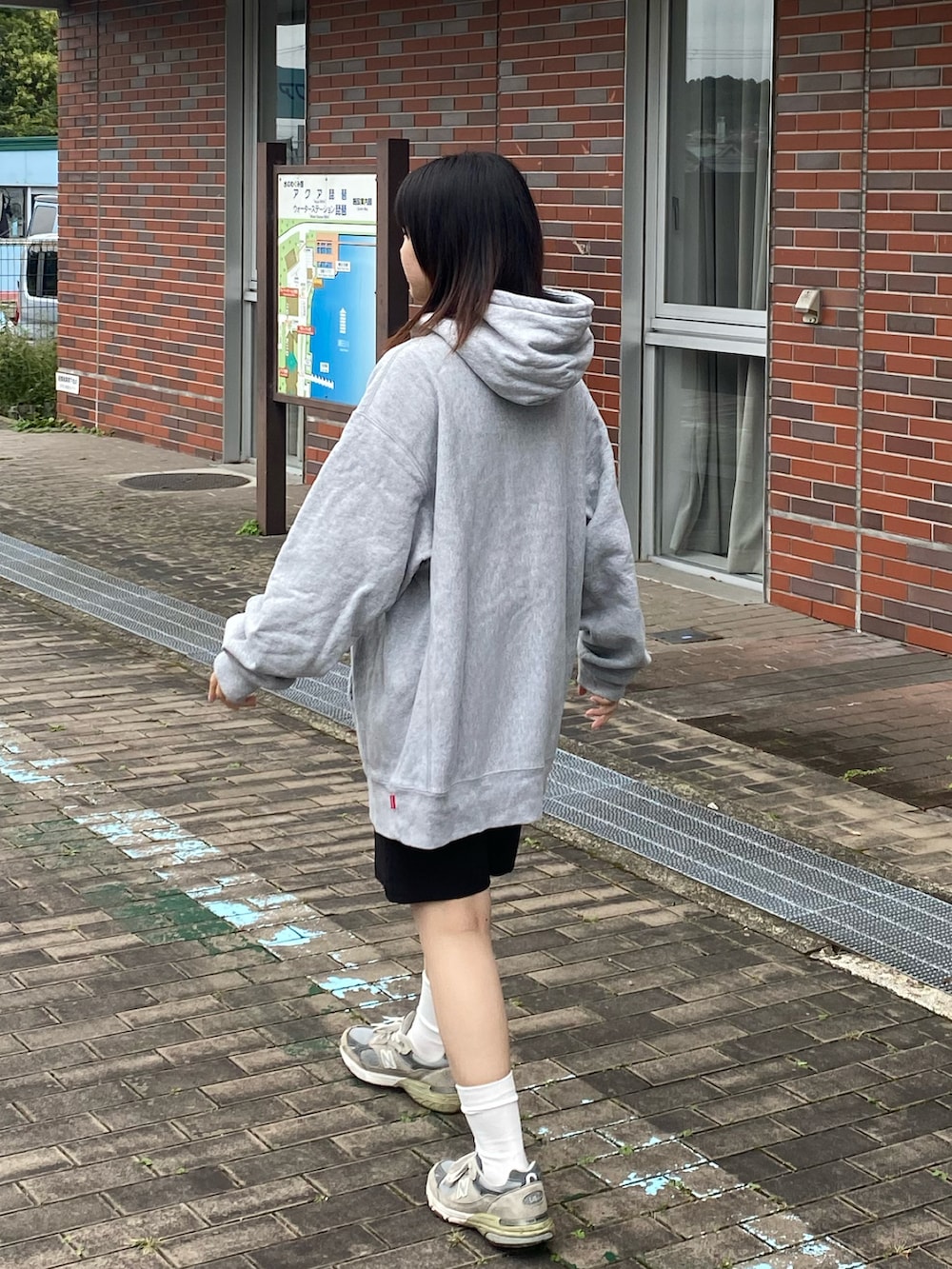 グレー系のスニーカー、ブラック系のその他パンツ、グレー系のパーカーを着用したレディースの秋コーディネートの2枚目の写真