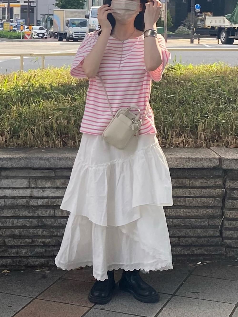 ホワイト系のTシャツ/カットソー、ホワイト系のスカート、ブラック系のブーツを着用したレディースの春コーディネートの2枚目の写真