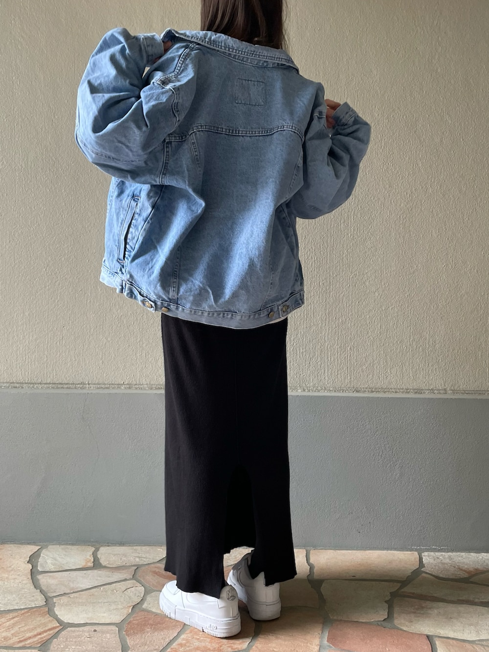 ブラック系のスカート、ホワイト系のスニーカーを着用したレディースの春コーディネートの2枚目の写真