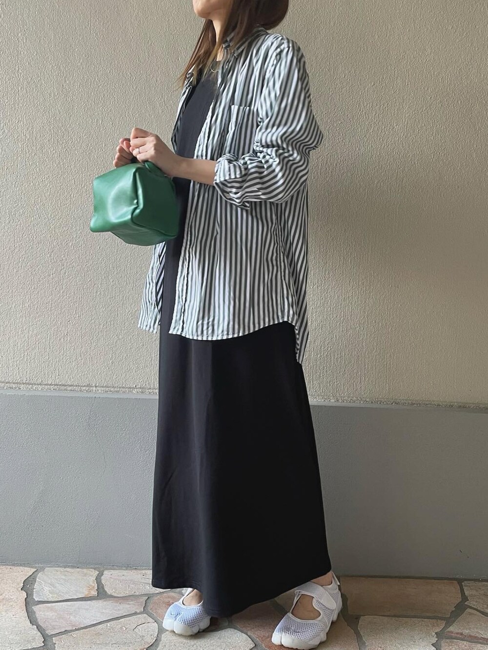 ホワイト系のスニーカー、グリーン系のハンドバッグを着用したレディースの春コーディネートの2枚目の写真