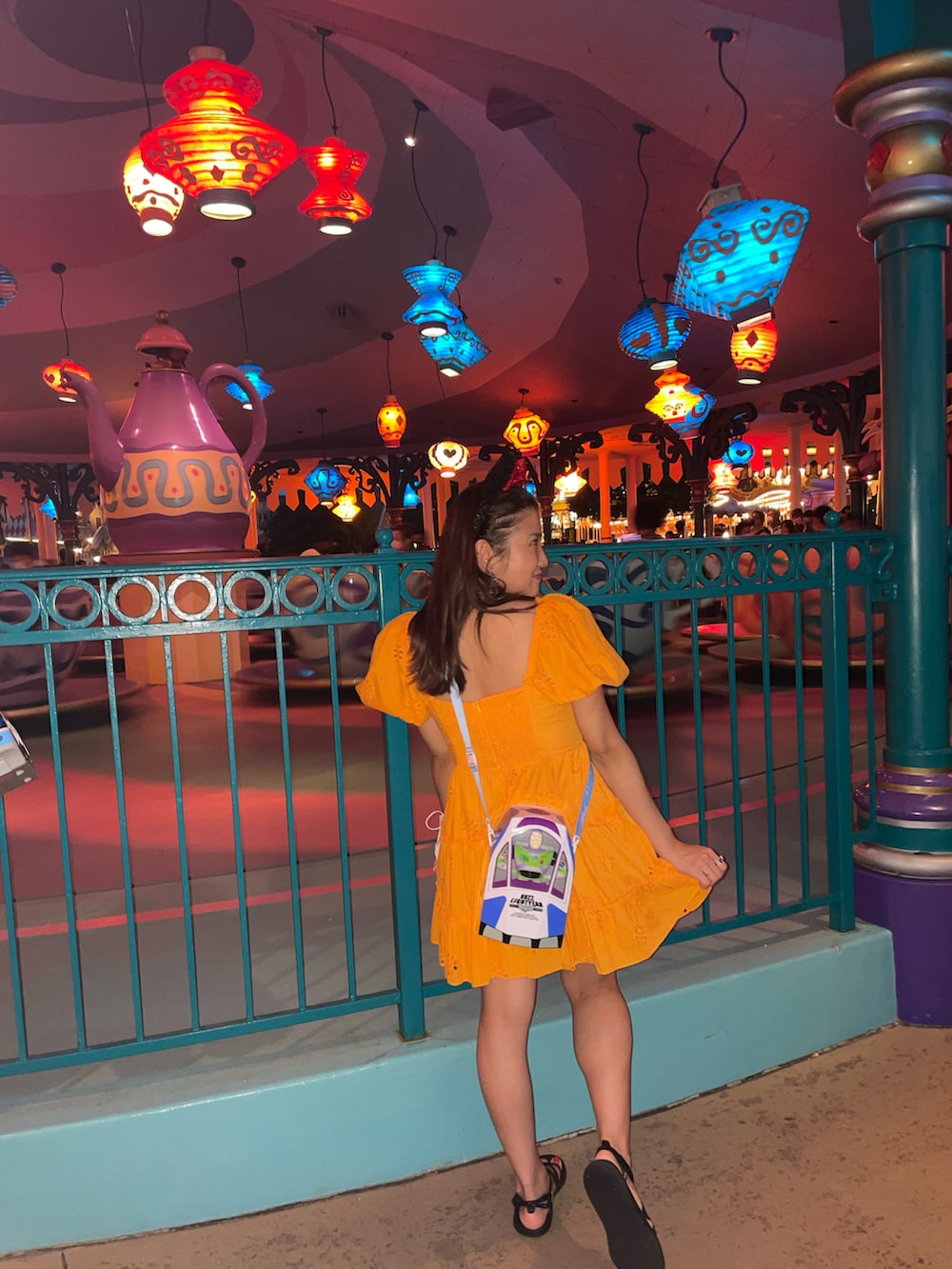 オレンジ系のワンピース/ドレス、ブラック系のサンダルを着用したレディースの秋コーディネートの2枚目の写真