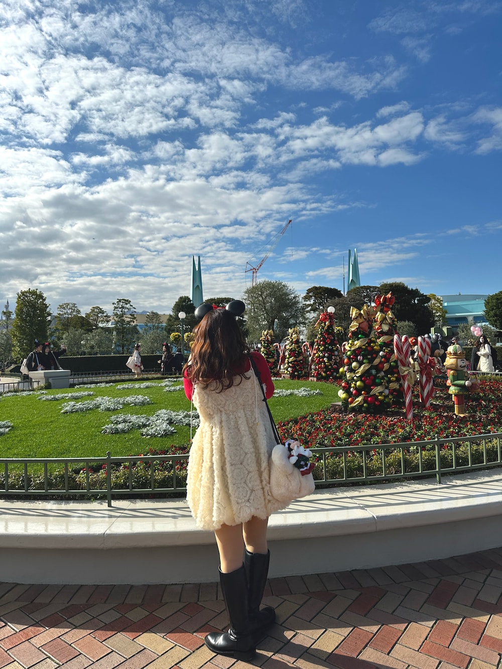 ホワイト系のワンピース、ブラック系のブーツを着用したレディースの冬コーディネートの4枚目の写真