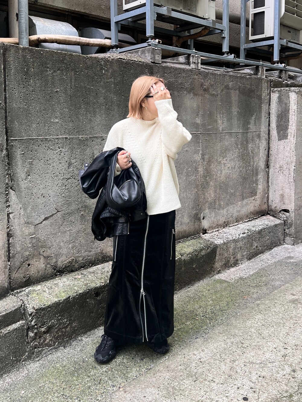 ホワイト系のニット/セーター、ブラック系のスカートを着用したレディースの秋コーディネートの2枚目の写真