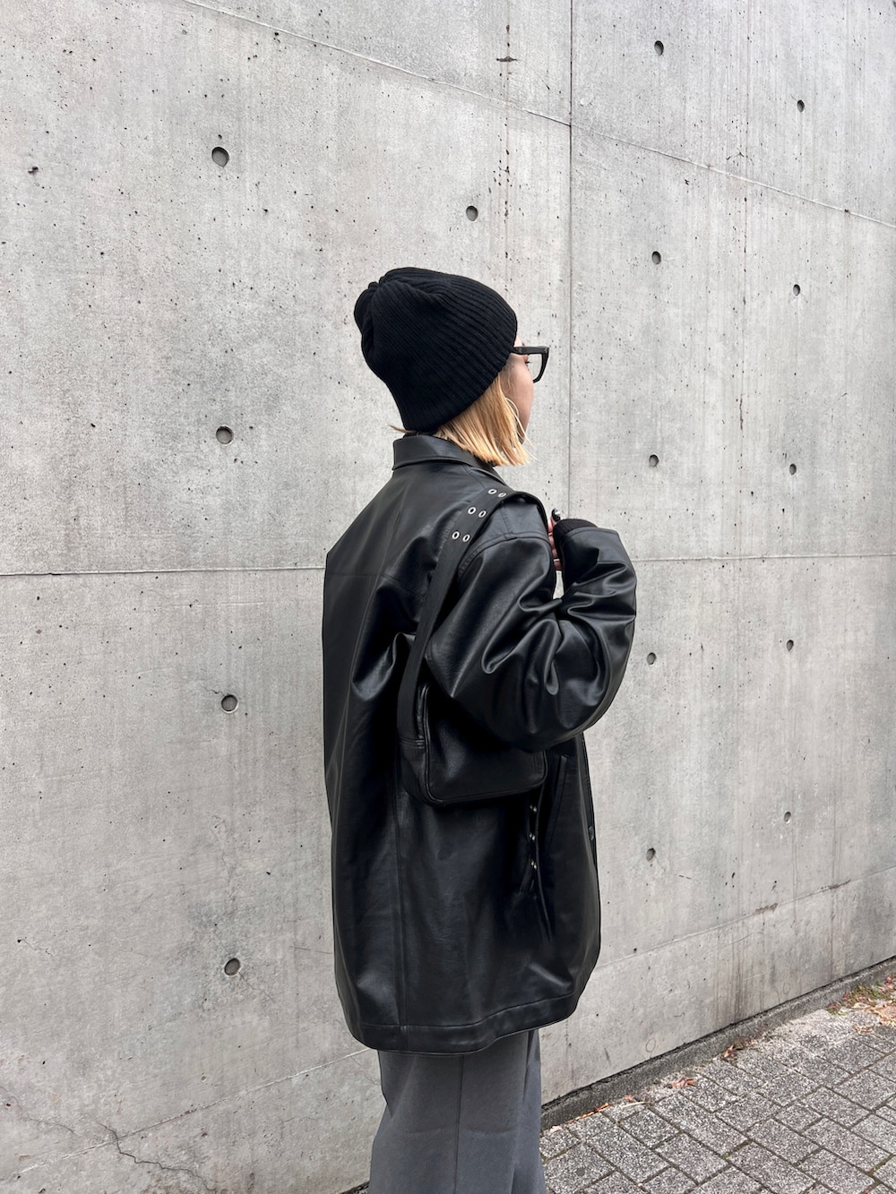 ブラック系のその他アウター、ブラック系のショルダーバッグ、ブラック系のニットキャップ/ビーニーを着用したレディースの冬コーディネートの3枚目の写真