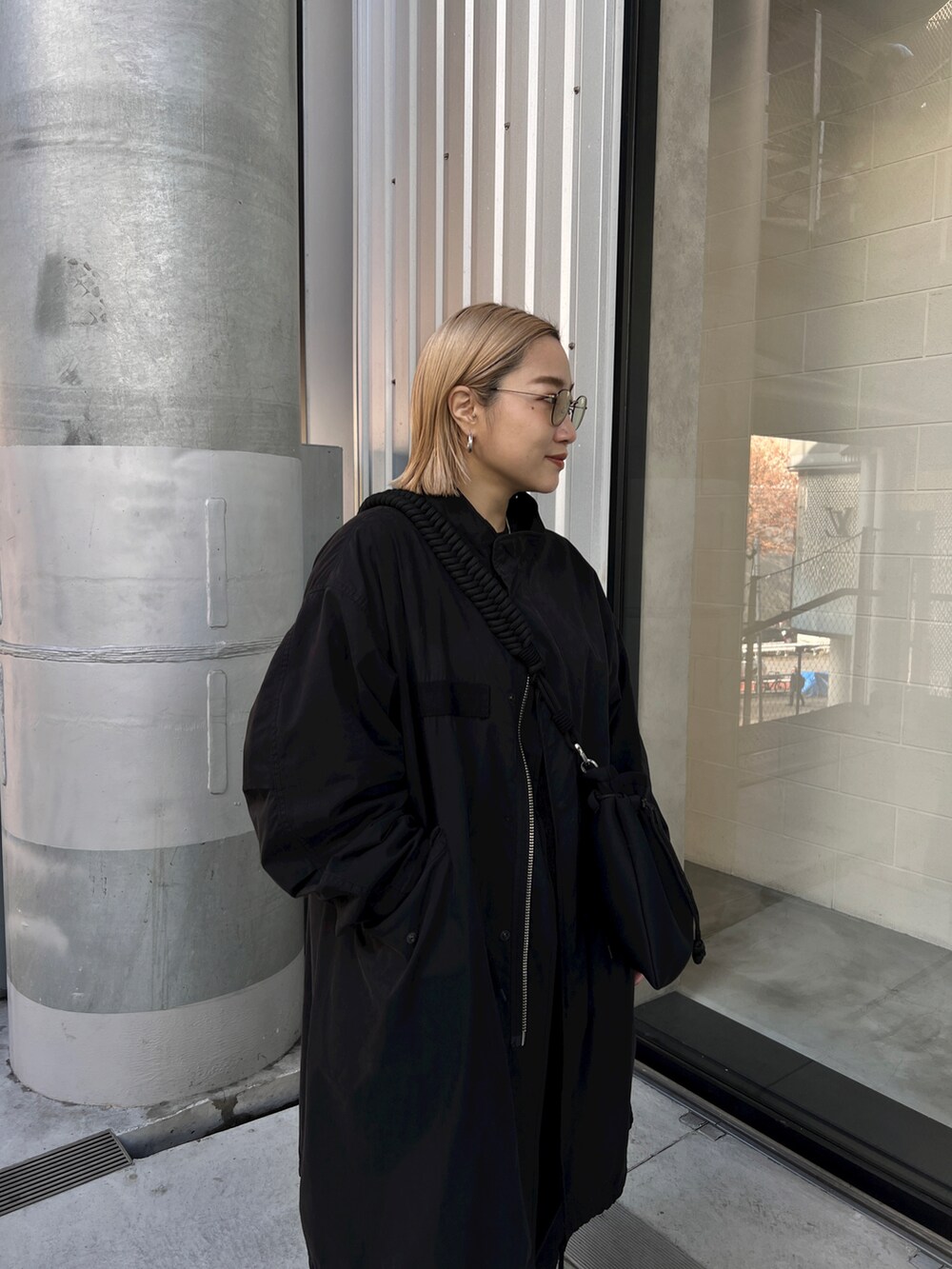 ブラック系のモッズコート、ブラック系のスニーカー、ブラック系のショルダーバッグを着用したレディースの冬コーディネートの3枚目の写真