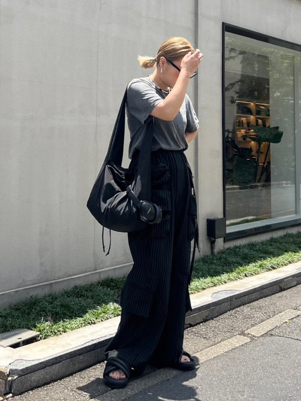 ブラック系のショルダーバッグ、ブラック系のパンツを着用したレディースの秋コーディネートの2枚目の写真