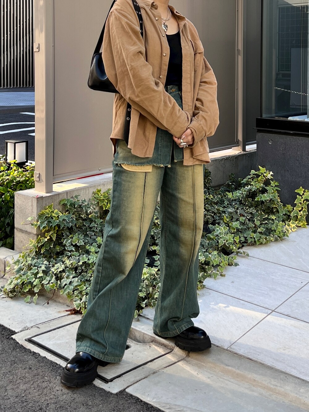 ブラック系のブーツ、その他のデニムパンツを着用したレディースの秋コーディネートの2枚目の写真