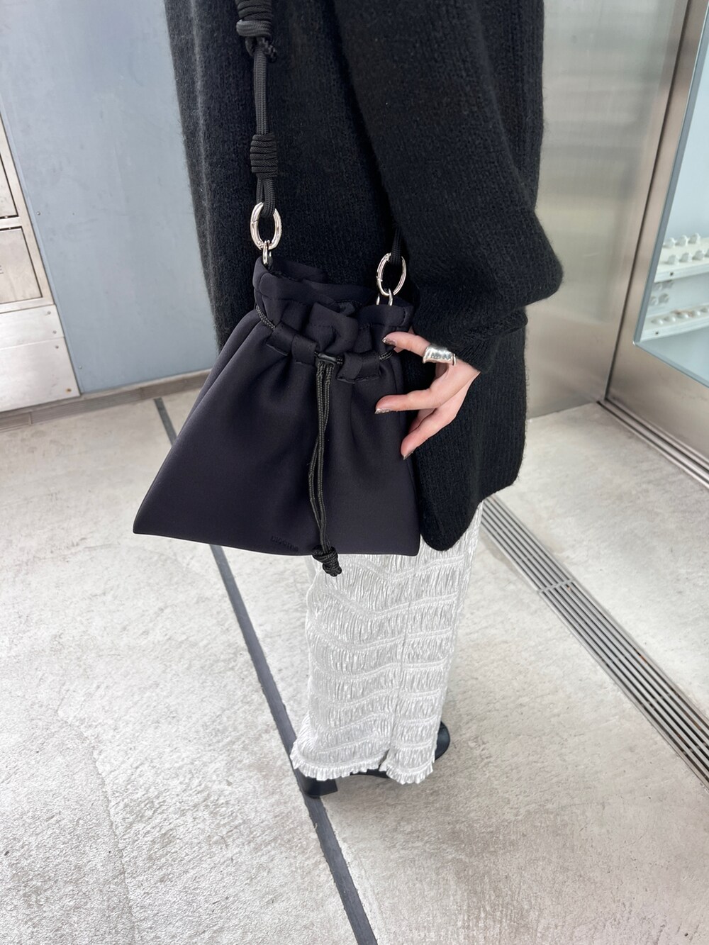 シルバー系のその他パンツ、ブラック系のショルダーバッグ、ブラック系のモッズコートを着用したレディースの冬コーディネートの2枚目の写真