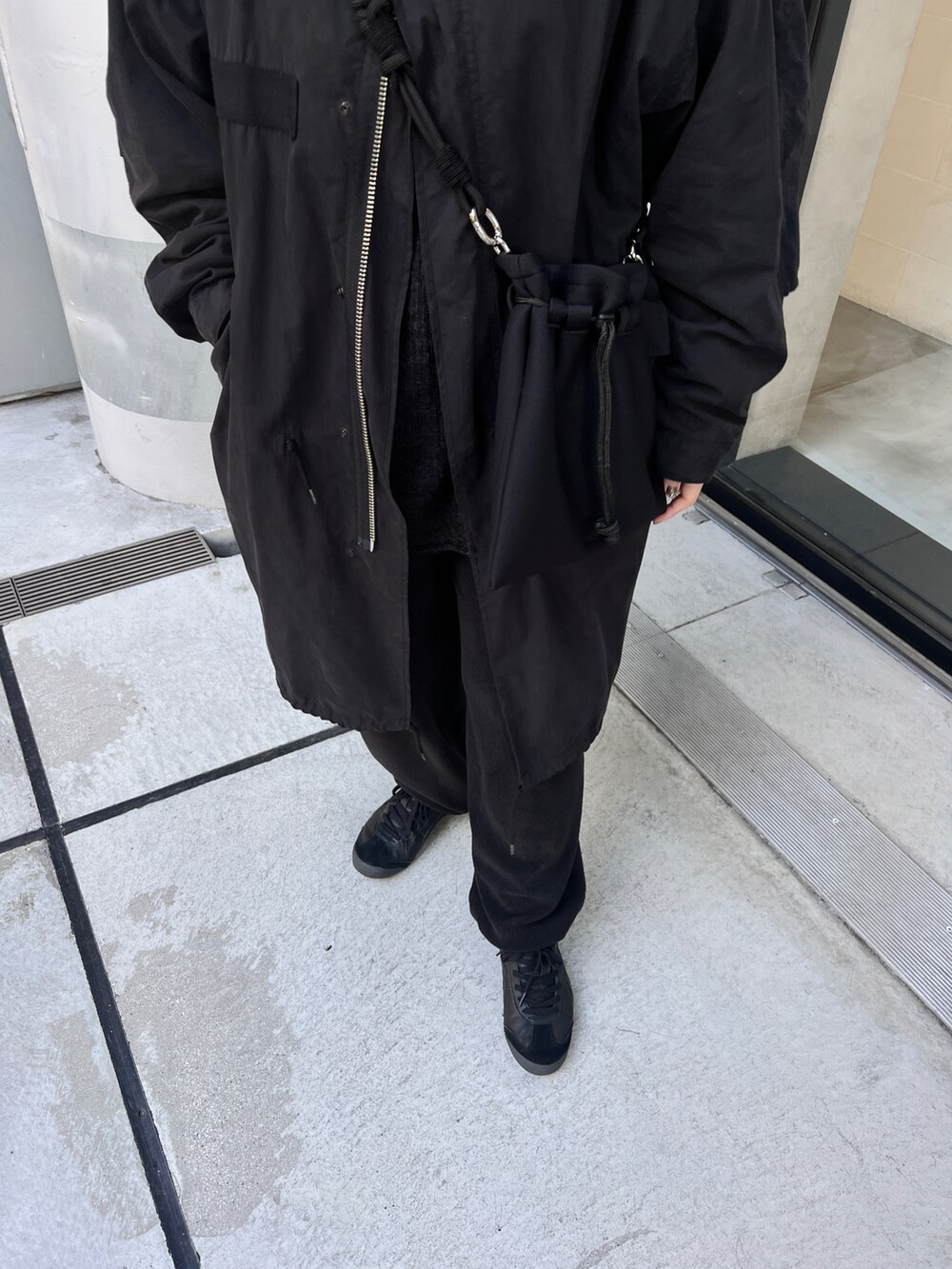 ブラック系のモッズコート、ブラック系のスニーカー、ブラック系のショルダーバッグを着用したレディースの冬コーディネートの2枚目の写真