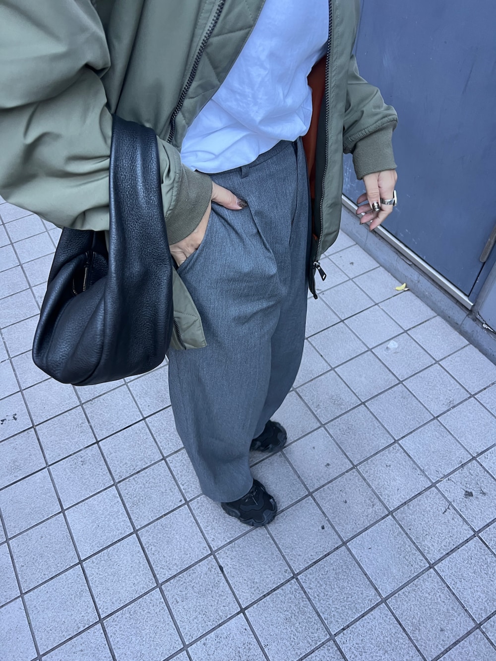 グリーン系のMA-1、グレー系のパンツ、ブラック系のスニーカーを着用したレディースの冬コーディネートの3枚目の写真