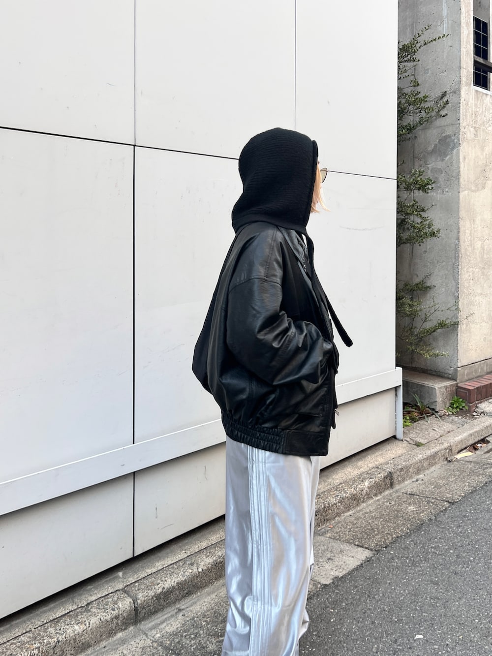 ブラック系のライダースジャケット、シルバー系のその他パンツ、ブラック系のニットキャップ/ビーニーを着用したレディースの冬コーディネートの2枚目の写真