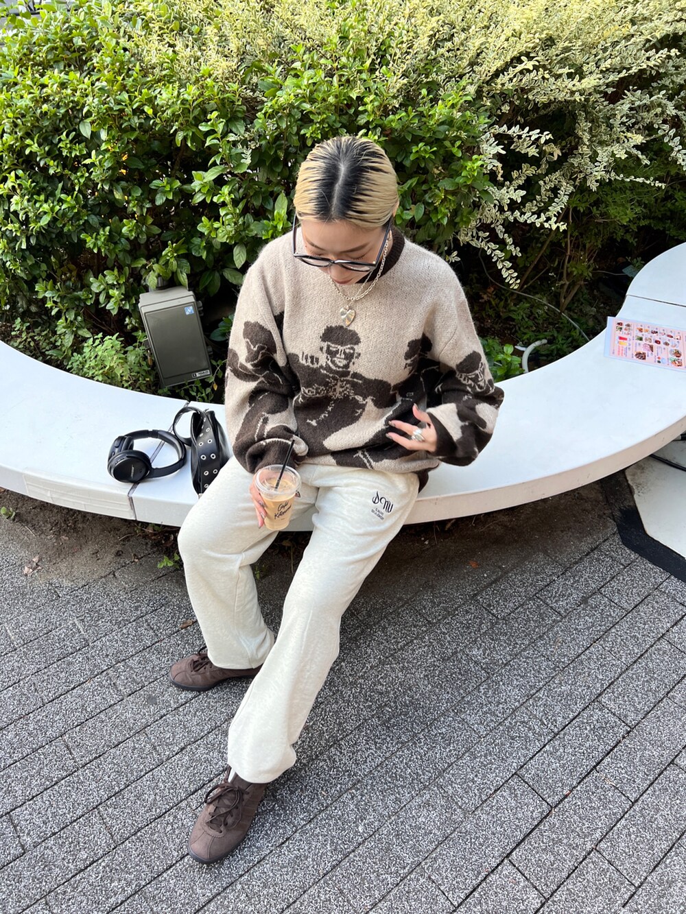 ベージュ系のニット/セーター、ブラック系のショルダーバッグ、ベージュ系のスウェットパンツを着用したレディースの秋コーディネートの2枚目の写真