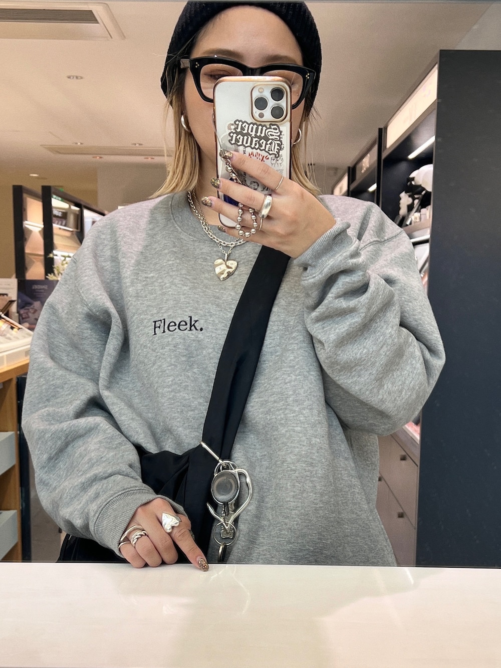 グレー系のパンツ、ホワイト系のスニーカー、グレー系のスウェットを着用したレディースの秋コーディネートの2枚目の写真