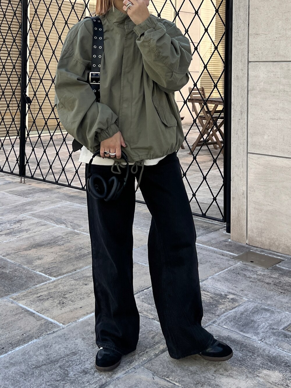 ブラック系のショルダーバッグ、ブラック系のスニーカーを着用したレディースの冬コーディネートの2枚目の写真