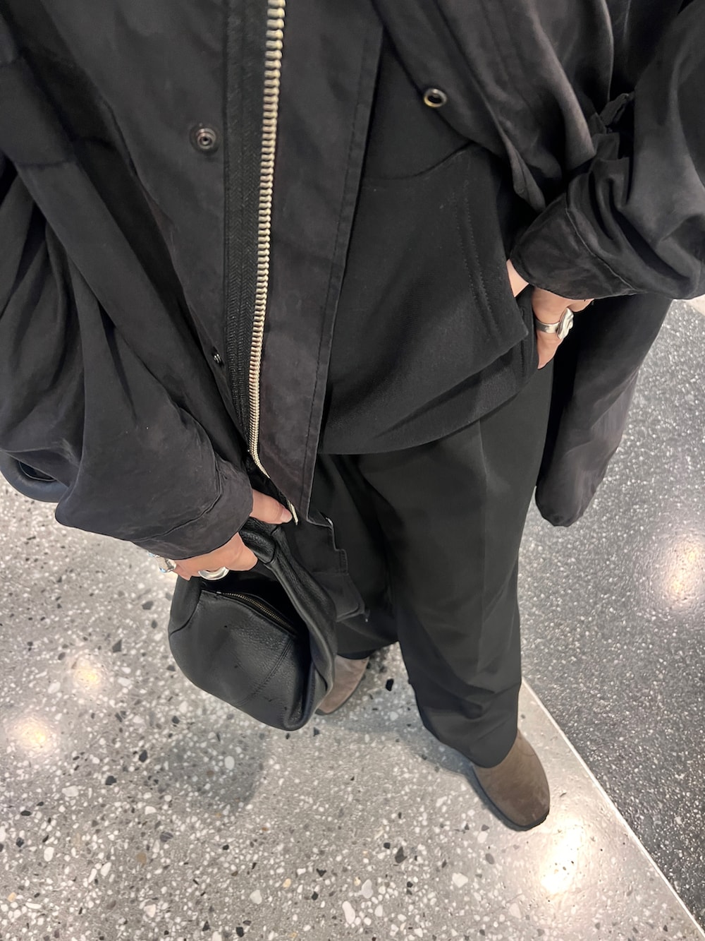 ブラック系のモッズコート、ブラック系のハンドバッグ、ブラック系のスリッポンを着用したレディースの冬コーディネートの2枚目の写真