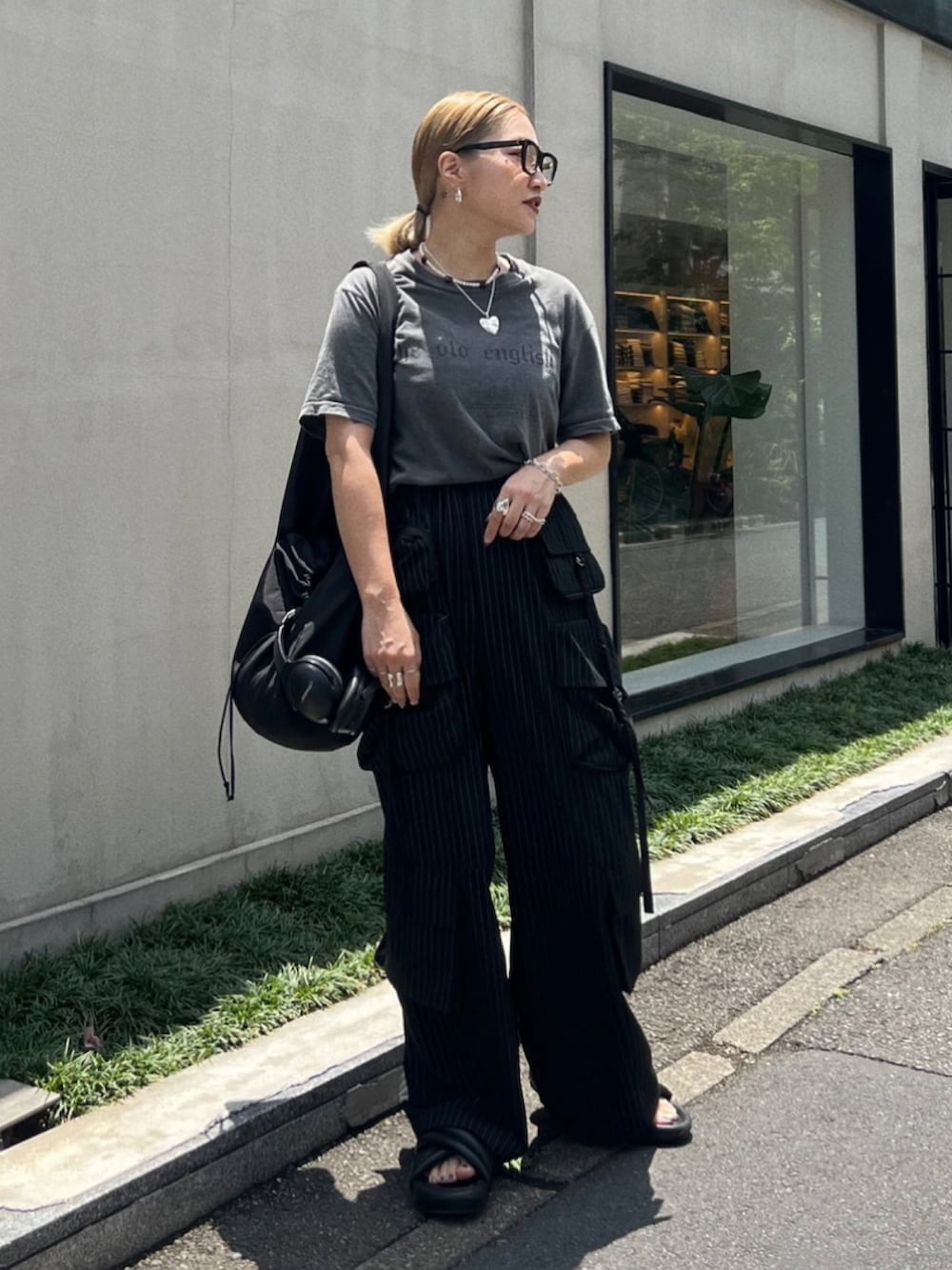 ブラック系のショルダーバッグ、ブラック系のパンツを着用したレディースの秋コーディネートの3枚目の写真