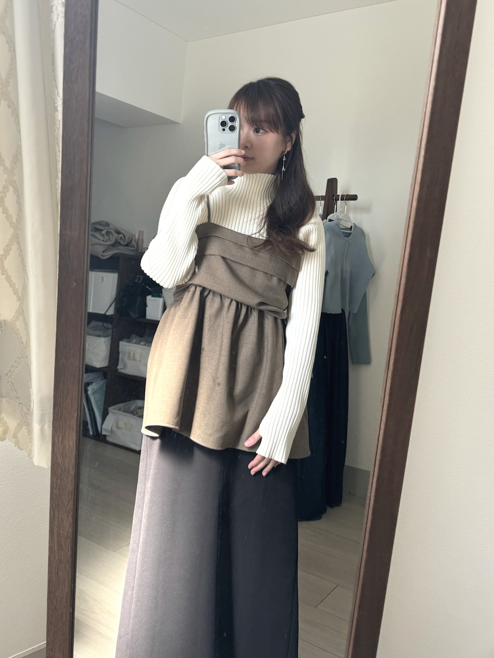 ブラウン系のワンピース、ブラック系のスカート、ホワイト系のニット/セーターを着用したレディースの冬コーディネートの2枚目の写真