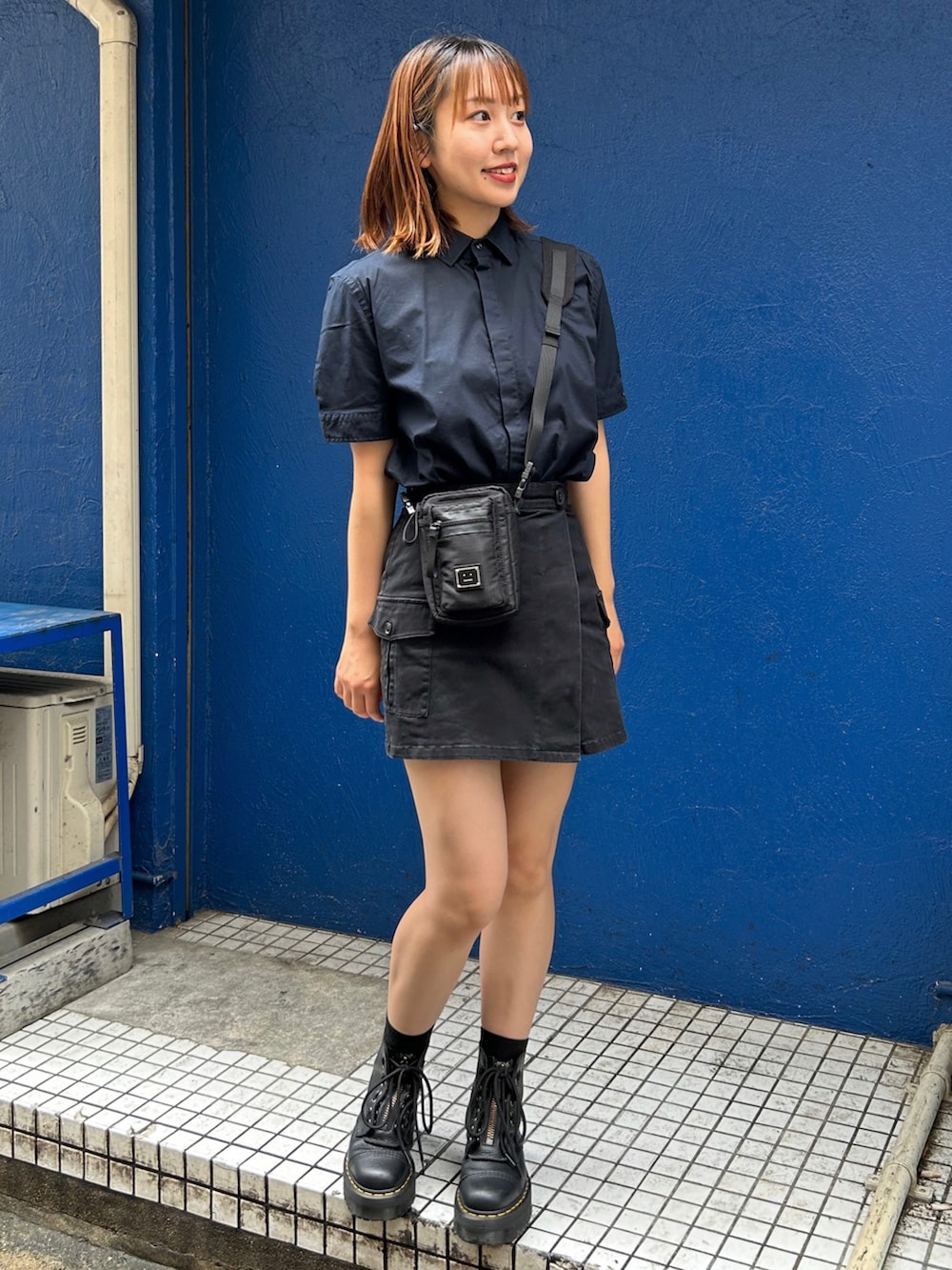 ブラック系のブーツ、ブラック系のスカート、ブルー系のシャツ/ブラウスを着用したレディースの夏コーディネートの2枚目の写真