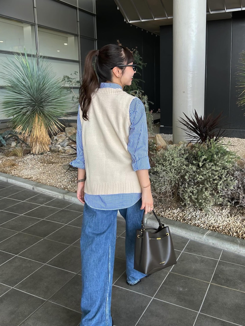 ブラック系のローファー、ブラウン系のショルダーバッグ、ブルー系のシャツ/ブラウスを着用したレディースの秋コーディネートの2枚目の写真